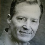Black and white headshot for James Hilton Burke. White male with short hair.