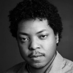 Black and white headshot for Andre Eaton Jr. Black male with curly black hair.