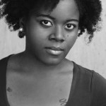 Black and white headshot for Felicia Jackson. Black female with short curly hair.