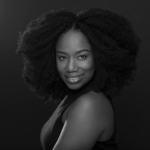 Black and white headshot for Tia Nickole. African American female with curly black hair.