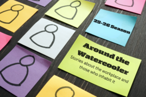 Logo for Live Arts 25-26 Season. Brightly colored posted notes on a dark wood desk. One Post it note says "25-26 Season" while the one below it says "Around the Water cooler: stories about the workplace and those who inhabit it".